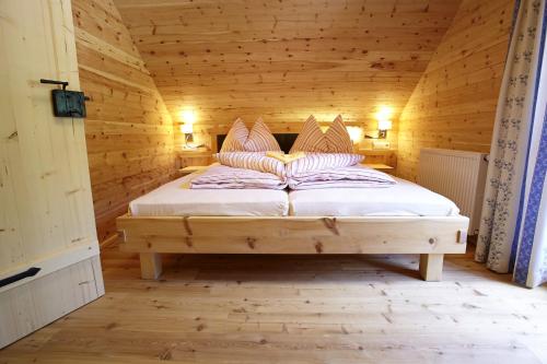 多内尔斯巴赫瓦尔德波道夫里斯诺度假屋的小木屋内一间卧室,配有一张床
