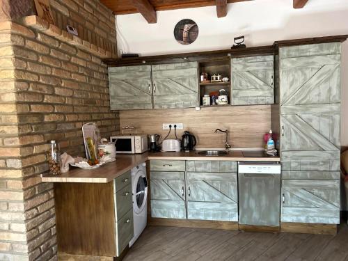 DégKisdió Vendégház的厨房设有绿色橱柜和砖墙