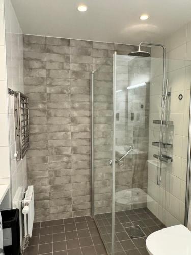 马尔默Tranquil and Convenience Southern Malmo Apartment的浴室里设有玻璃门淋浴