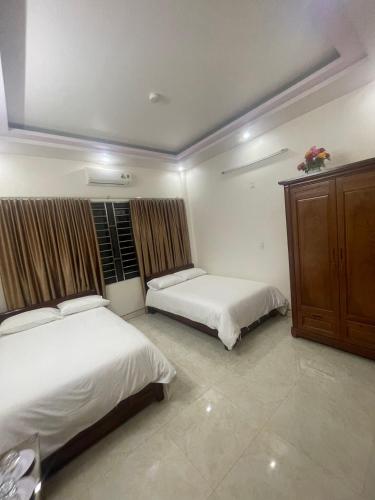 河江Holly's Hostel Ha Giang B&B的一间卧室设有两张床和木制橱柜