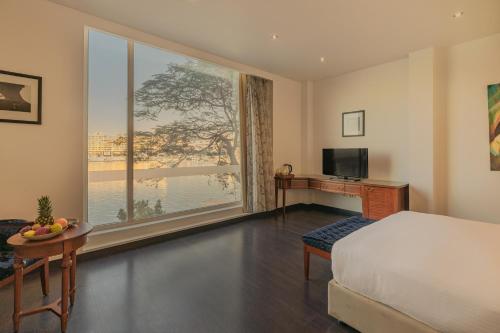 开罗Riverside Hotel的一间卧室设有大窗户、一张床和一张书桌