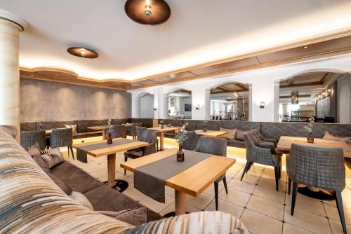 朗根费尔德丽塔酒店的餐厅设有桌椅和沙发。