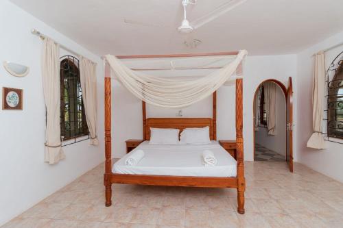 瓦塔穆Sal & Lala Castle watamu的一间卧室配有一张带天蓬的床