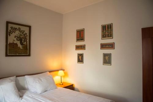 克拉科夫Kompleksowo wyposażony apartament w centrum的卧室配有一张床,墙上挂有图片