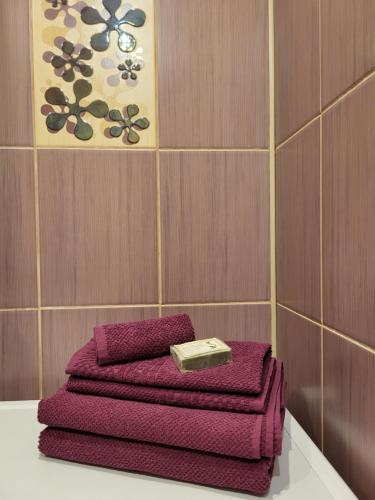 里加Iļģuciema Apartment的浴室桌子上摆放着三条紫色毛巾