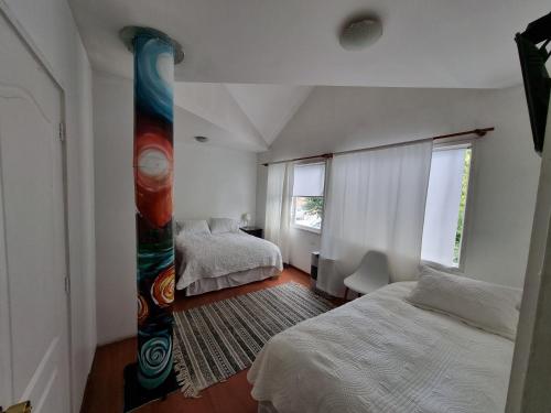 科伊艾科Hostal Casa Arrayán的一间卧室设有两张床和大窗户