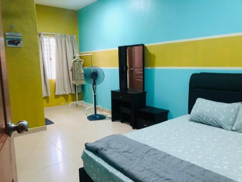 芙蓉SOFEA HOMESTAY Islam sahaja的一间卧室设有一张床,墙壁为蓝色和黄色