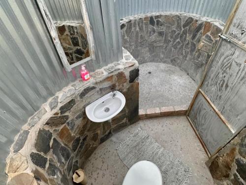 UisDaureb Isib Campsite and B&B的石质浴室设有卫生间和窗户。