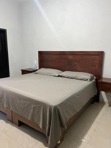 圣玛丽戴尔奥罗Casa de la esquina的卧室内的一张带木制床头板的床