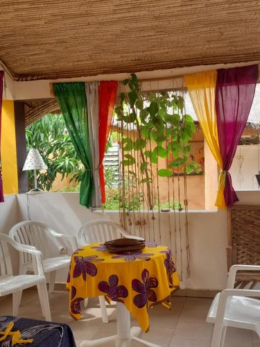PoponguineCampement Baobab的一张桌子和椅子,房间配有色彩缤纷的窗帘