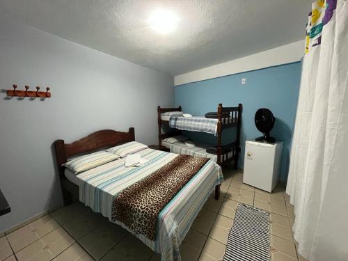 特林达德Pousada Gaivotas的一间卧室配有一张床和一把椅子