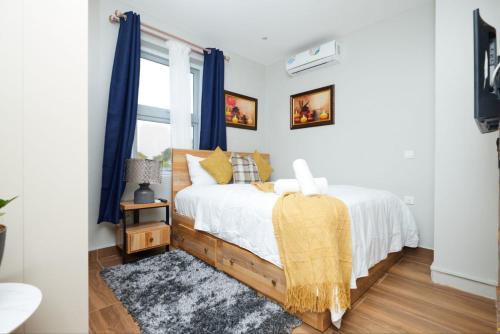 阿克拉Perfect Luxury @ Henrietta’s Residence的一间卧室配有蓝色窗帘的床