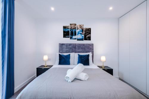 伯明翰Sterling Suite - Modern 2 Bedroom Apartment in Birmingham City Centre - Perfect for Family, Business and Leisure Stays by Dreamluxe的卧室配有带蓝色枕头的大型白色床