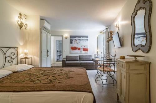 阿维尼翁Aux Augustins Palais des Papes & Wellness的一间卧室配有一张大床和一张沙发