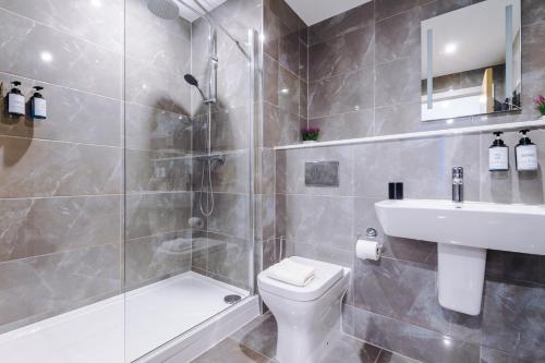 伯明翰Sterling Suite - Modern 2 Bedroom Apartment in Birmingham City Centre - Perfect for Family, Business and Leisure Stays by Dreamluxe的带淋浴、卫生间和盥洗盆的浴室