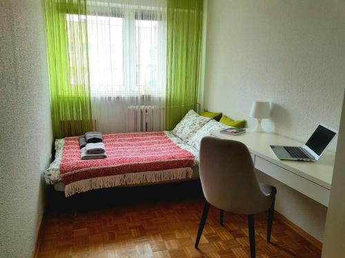 华沙Wygodny dwupokojowy apartament pomiedzy lotniskiem a centrum的一间卧室配有一张带书桌和笔记本电脑的床。