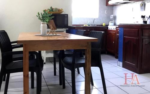 图斯潘罗德里格斯卡诺Hospedaje Aldana - Casa LA VISTA en zona verde的厨房配有木桌和椅子
