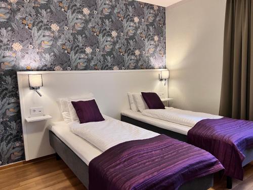 玛丽斯塔德维多利亚酒店的紫白色客房的两张床
