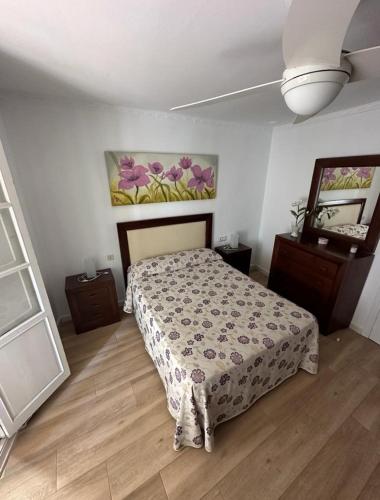 桑卢卡尔-德巴拉梅达Casa Mari的卧室配有一张床,墙上挂有绘画作品