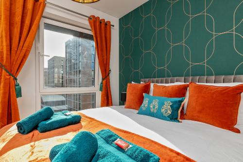卢顿Luxury Apartment-Free Parking-Central Location的一间卧室配有带橙色和蓝色枕头的床