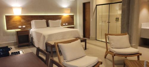朱奎Hiu Hotel的酒店客房,配有一张床和两把椅子