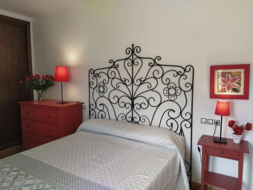 奥里韦拉德尔特雷梅达尔Apartamento Gandía, Orihuela del Tremedal.的一间卧室配有一张床和一个带两盏灯的梳妆台。