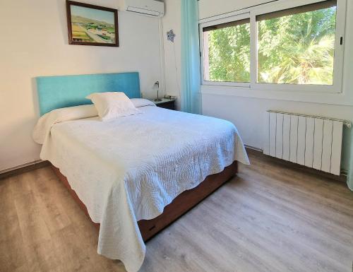 滨海普雷米亚Pool and relax 20' from Barcelona的一间卧室配有一张带蓝色床头板的床和窗户