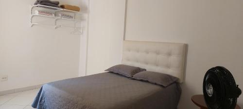 维多利亚-达孔基斯塔Apartamento completo e bem localizado的白色卧室配有带2个枕头的床