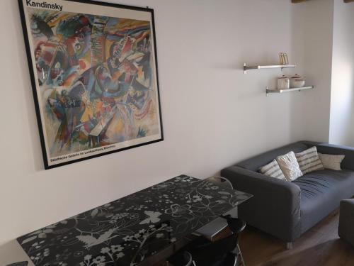 贝加莫Appartamento in centro Bergamo的客厅配有沙发和墙上的绘画