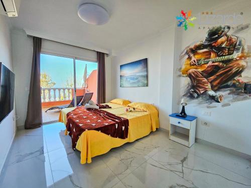 圣地亚哥港7Lizards - Ocean View Apartments的卧室配有一张床,墙上挂有绘画作品