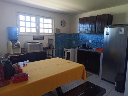 嘎林海斯港Privê Recanto da Enseada - Serrambi的厨房配有一张桌子,上面有黄色的桌布