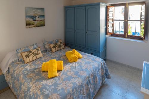 格拉纳达Casa Asia的一间卧室配有蓝色的床,上面有黄色的毛巾