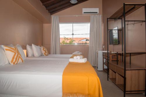 布希奥斯Porteño Loft Búzios的卧室配有一张大白色床和窗户
