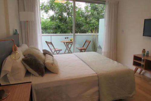 布宜诺斯艾利斯Palermo live的卧室设有一张白色大床和一扇窗户。