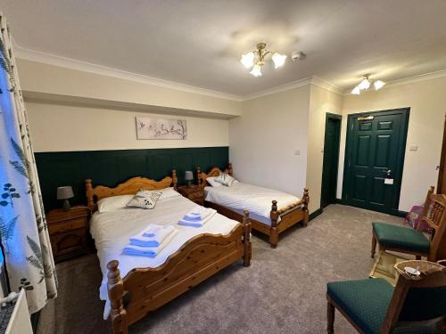 廷瓦尔亨利斯雷别墅酒店的一间卧室配有两张床和椅子