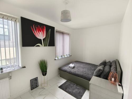 曼彻斯特Shared House - 10 mins from Piccadilly Station/Man Uni/O2 Apollo的卧室配有沙发,墙上挂着红花