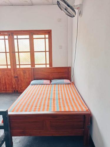 阿努拉德普勒Puraya'S Lodge的窗户客房内的木床