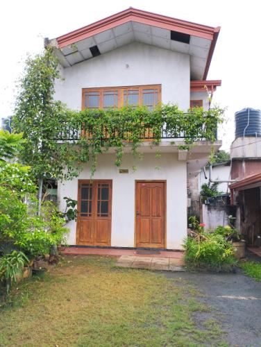 阿努拉德普勒Puraya'S Lodge的白色的房子,设有木门和院子