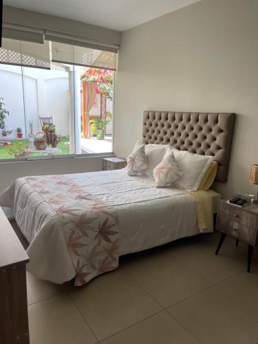 莫克瓜Apart-hotel Villakayro的一间卧室设有一张大床和大窗户