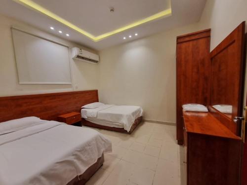 利雅德دار داكن للشقق المخدومة的酒店客房设有两张床和窗户。