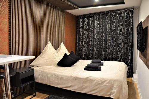 不莱梅安韦德希公寓民宿的卧室配有一张带黑色窗帘的白色床