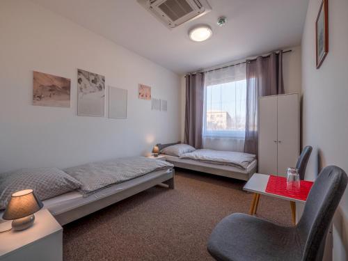尼特拉Penzion ARIES的一间卧室配有一张床、一张书桌和一个窗户。