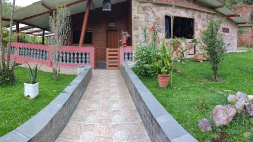 瓜鲁柳斯Chácara, 3 suítes, piscina, lago, wi-fi 250 mbps的一座花园,在房子前面种植盆栽植物