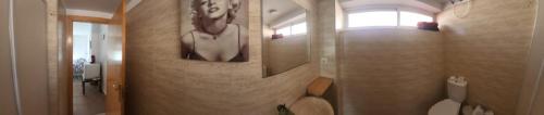 阿尔么丽亚Habitaciones en Casa compartida Retamar的浴室墙上有一幅女人的画