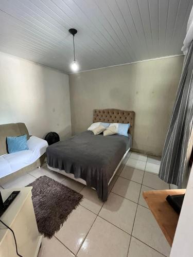 布卢梅瑙Casa com suíte的一间卧室配有一张床和一张沙发
