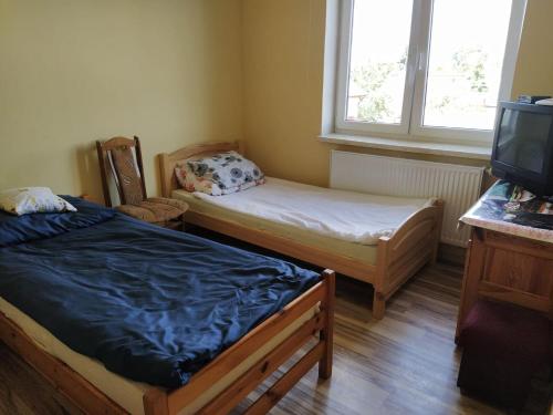 切哈努夫Pokoje Goscinne Buzuki的小房间设有两张床和电视