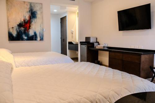 纳沃华Hotel Gran Avenida, Navojoa的酒店客房配有两张床和一张书桌