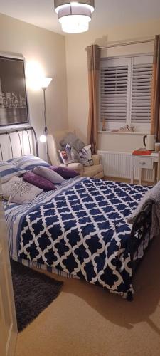 BuckinghamshireAylesbury Lovely Double and Single Bedroom with Guest only Bathroom的一间卧室配有一张带蓝色和白色棉被的床