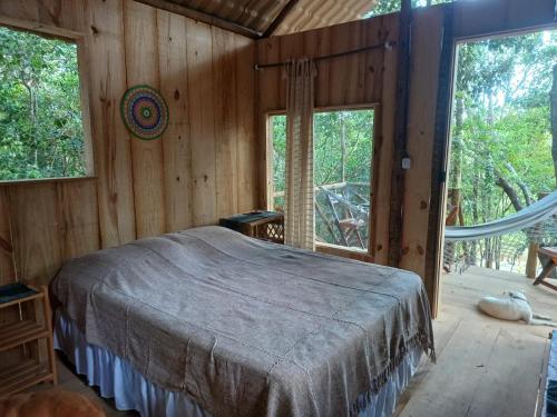 普拉亚多RECANTO DO SENTIR, conexão com a natureza e muita paz.的一间设有床铺的卧室,位于带窗户的房间内
