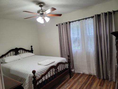 Tranquil Retreat in the heart of Bethany的一间卧室配有一张带吊扇和窗户的床。